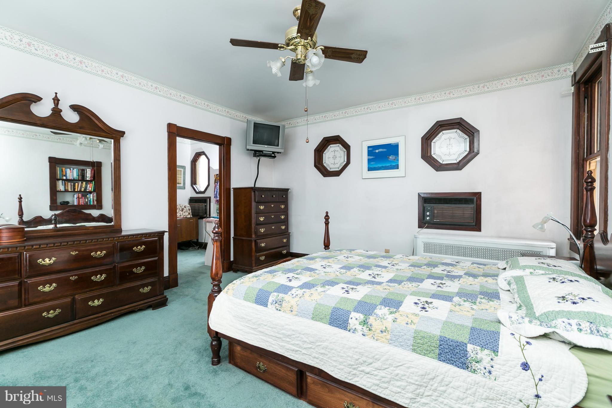 4015 Roland Avenue Baltimore, MD 21211 - Photo 14 of 30 a bedroom with a bed and a chandelier