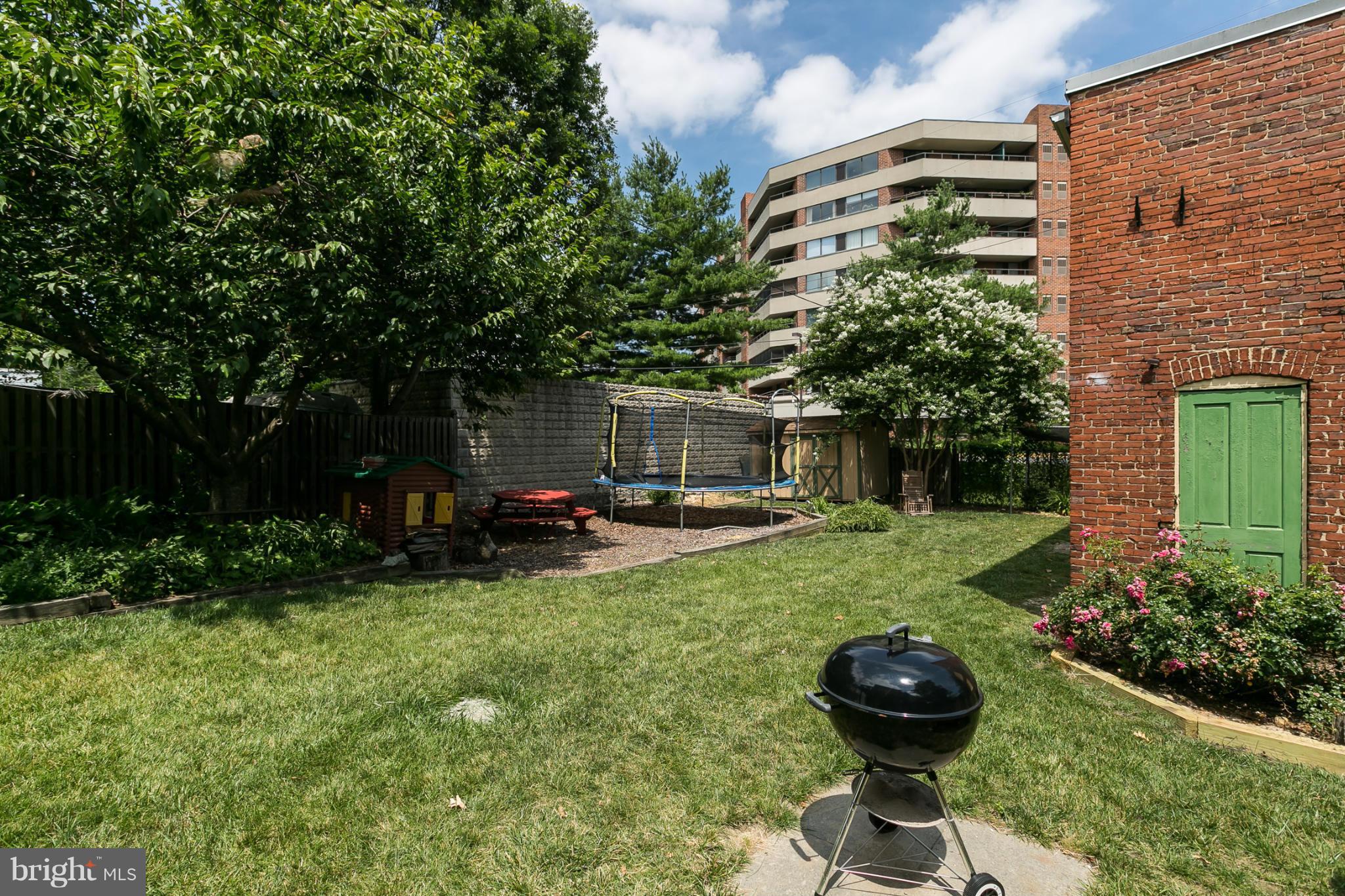 4015 Roland Avenue Baltimore, MD 21211 - Photo 27 of 30 a view of a backyard with table and chairs potted plants and a large tree