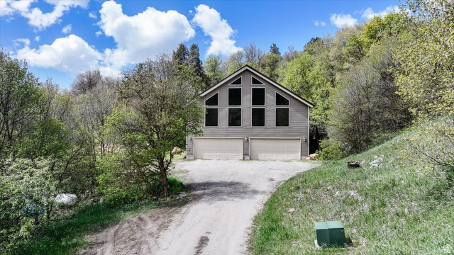 7203 East Cub River Road Preston, ID 83263 - Photo 27 of 33 View of front facade featuring driveway, a garage, and view of wooded area