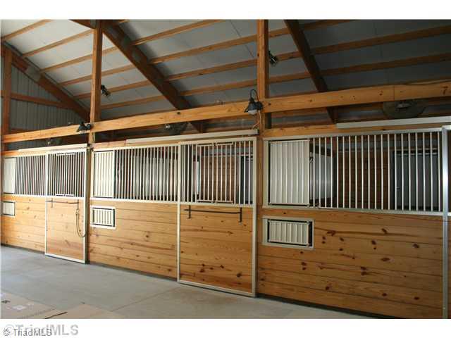 6388 Gumwood Road Oak Ridge, NC 27310 - Photo 8 of 9 Stable/Barn. jView from the center aisle of the 6-stall barn