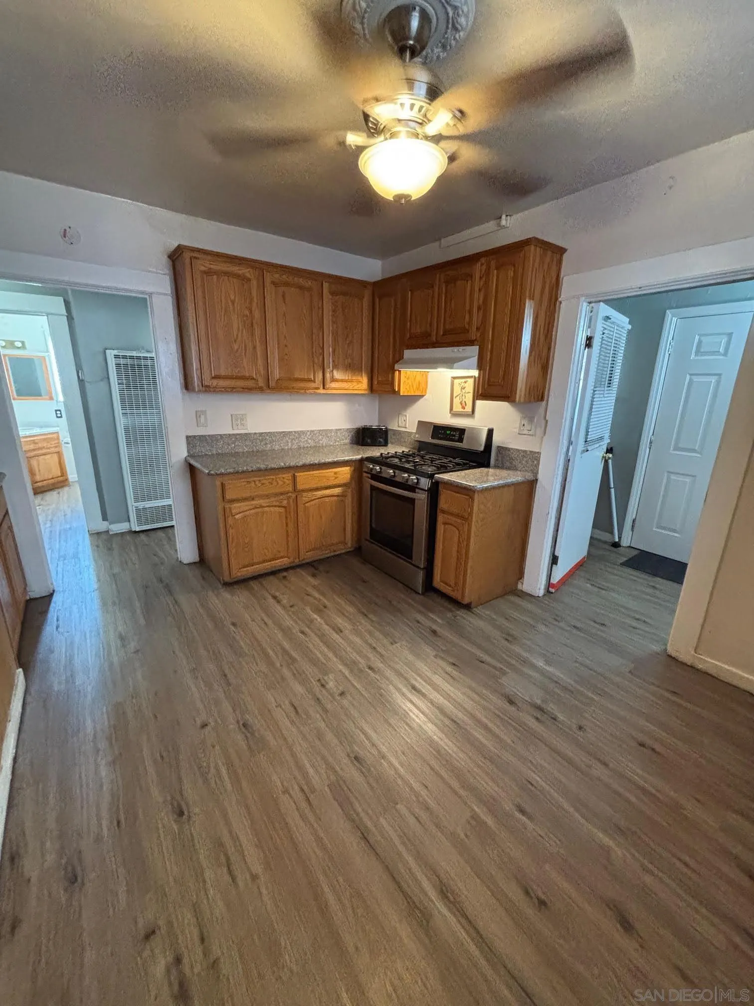 2925 Franklin Avenue San Diego, CA 92113 - Photo 11 of 36 a kitchen with stainless steel appliances wooden floors and view living room