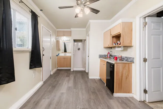 a view of a kitchen with refrigerator and wooden floor