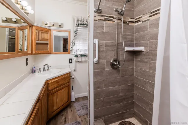 a bathroom with a tub sink a mirror and shower
