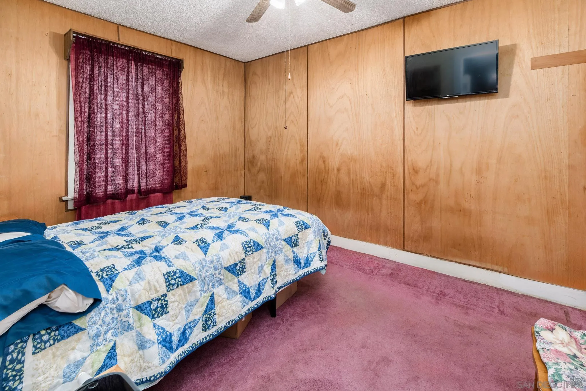 2925 Franklin Avenue San Diego, CA 92113 - Photo 10 of 36 a bedroom with a bed tv and wooden floor