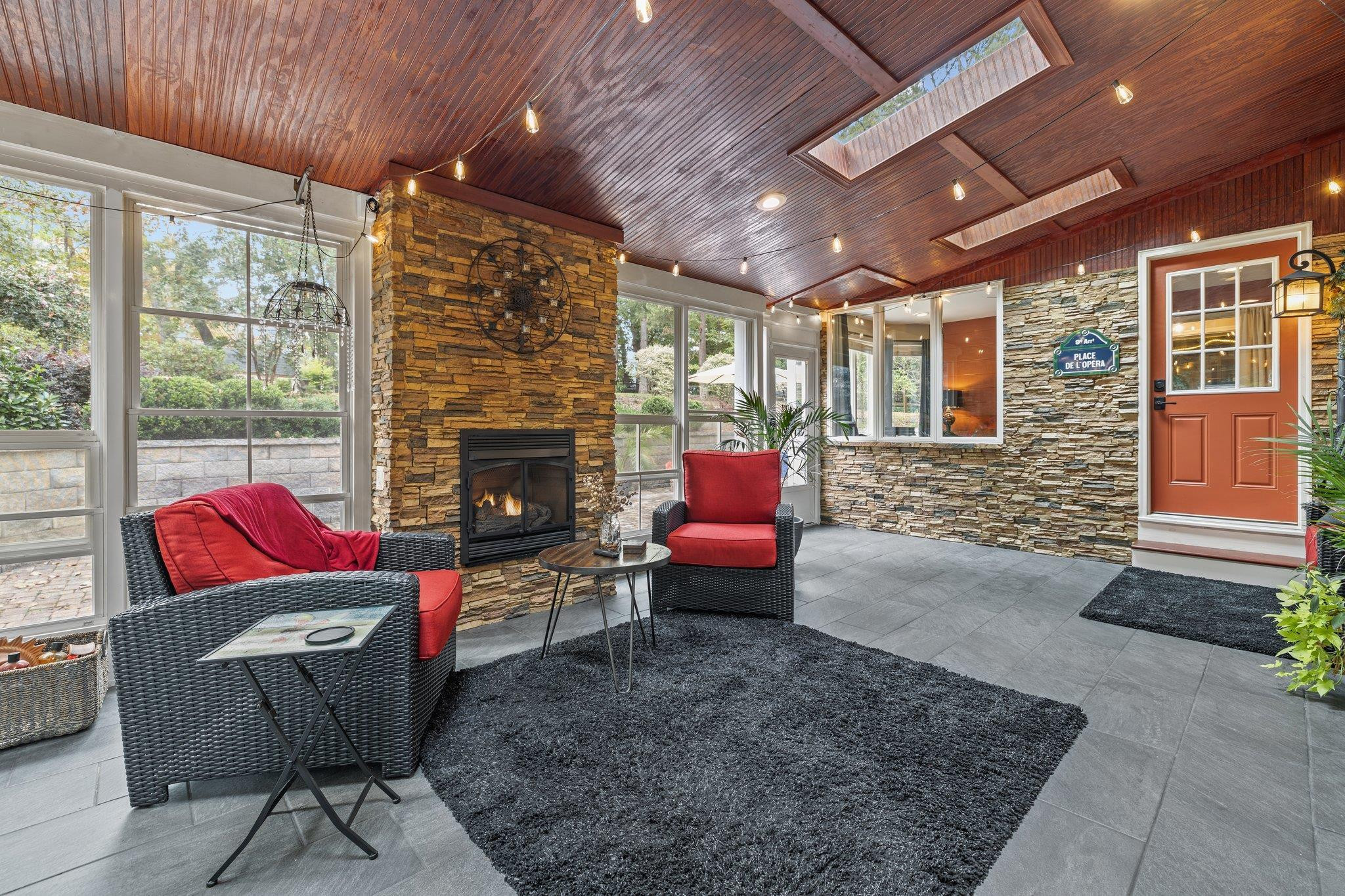 6305 Rushingbrook Drive Raleigh, NC 27612 - Photo 10 of 48 a living room with furniture a fireplace and a floor to ceiling window