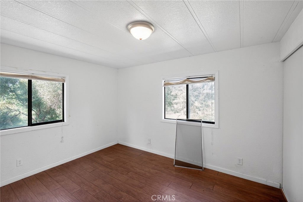 3804 Owl Creek Road Mariposa, CA 95338 - Photo 9 of 18 an empty room with wooden floor and windows