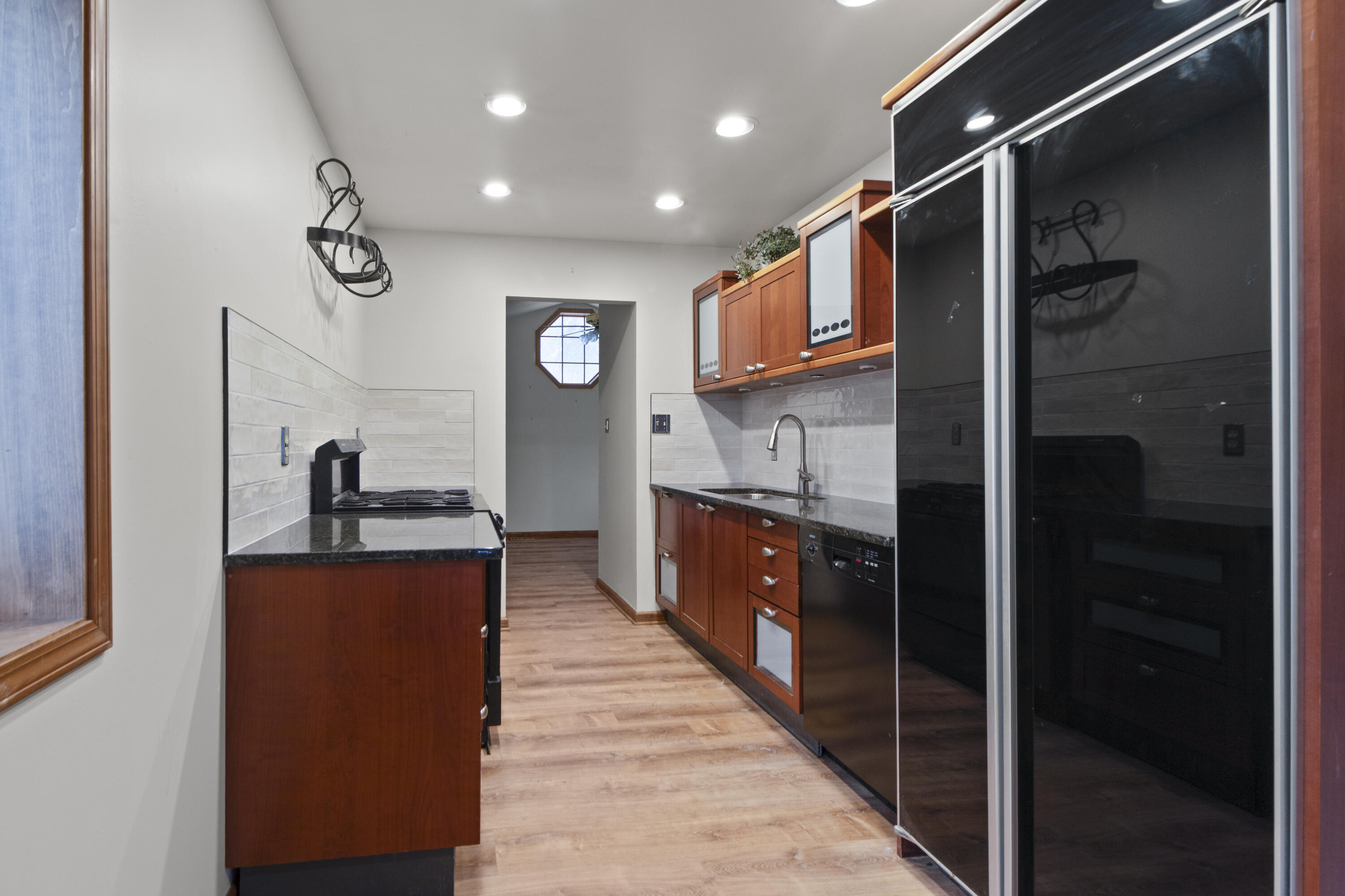 6610 East 3rd Avenue Gary, IN 46403 - Photo 5 of 24 a kitchen with stainless steel appliances granite countertop a sink and a refrigerator