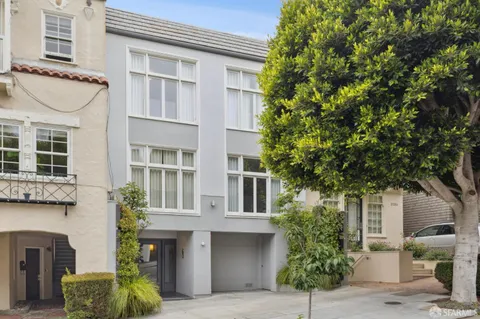 a front view of a house with plants