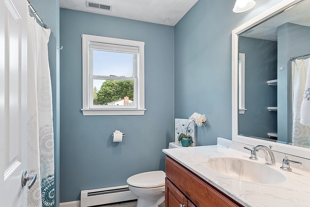 16 Choate Avenue Danvers, MA 01923 - Photo 16 of 32 a bathroom with a granite countertop toilet a sink and a mirror