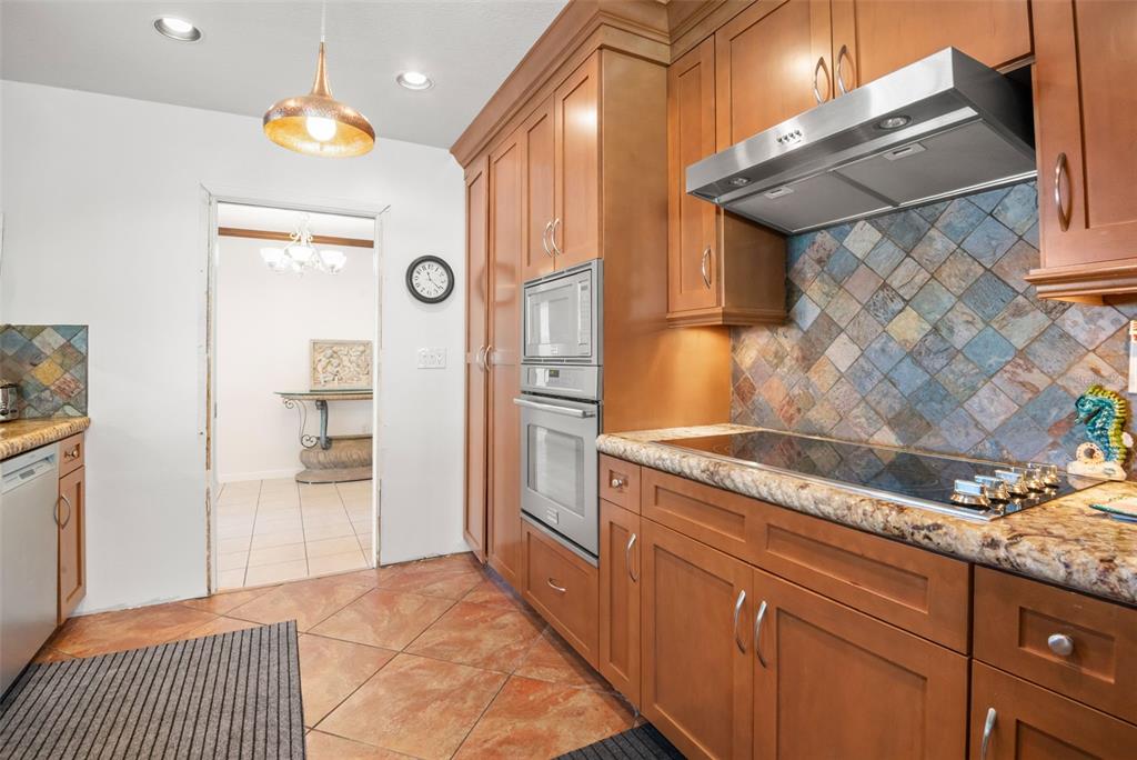 5451 Windward Way New Port Richey, FL 34652 - Photo 9 of 36 a kitchen with granite countertop cabinets and steel stainless steel appliances