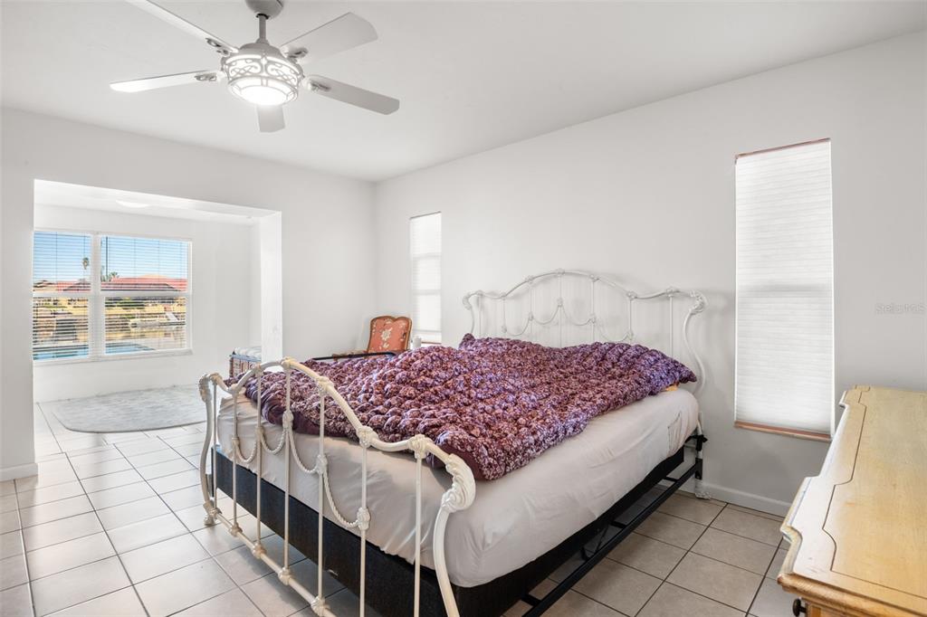 5451 Windward Way New Port Richey, FL 34652 - Photo 10 of 36 a bedroom with a bed and a chandelier