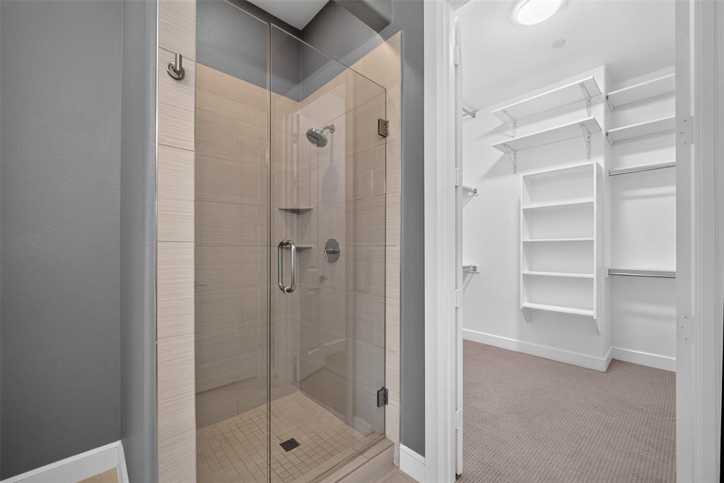 5015 Meridian Lane, Unit 2102 Addison, TX 75001 - Photo 22 of 36 Glass-enclosed shower with tile surround and integrated shelving, featuring a chrome shower head and fixtures