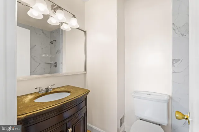 a bathroom with a sink a toilet and a mirror