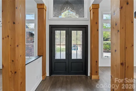 a view of a hallway with wooden floor and a kitchen