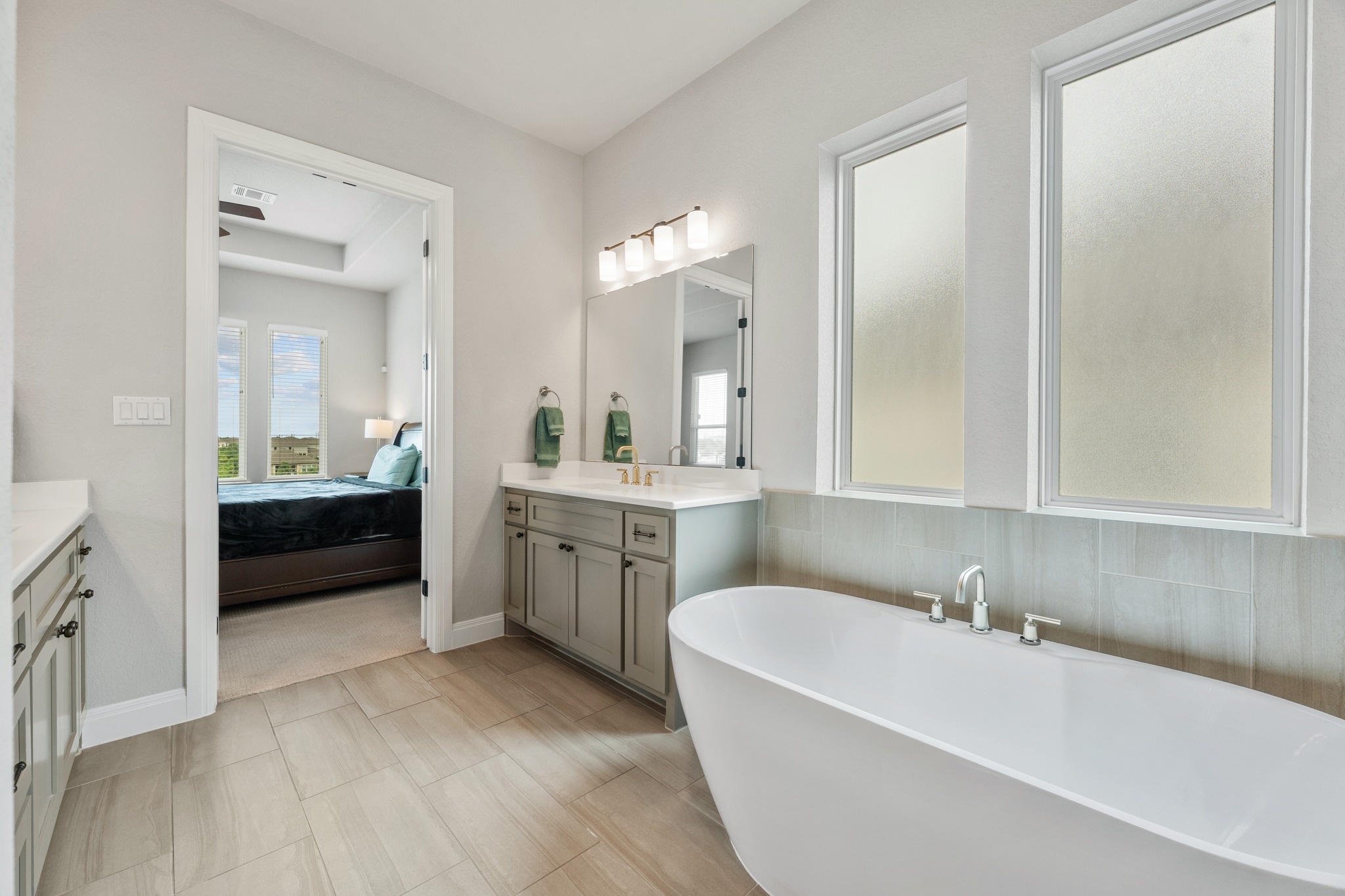 510 Elworth Path Austin, TX 78738 - Photo 13 of 40 a bathroom with a tub a sink a mirror and a shower