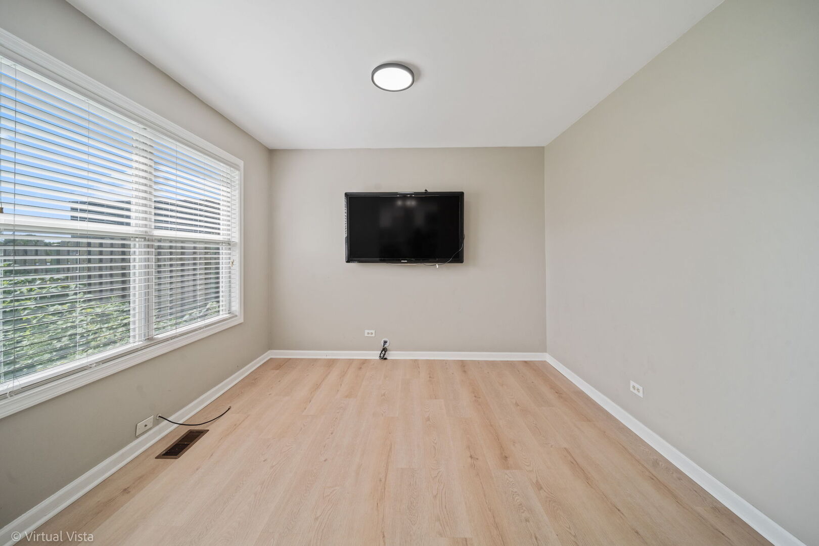 1402 Walnut Circle Carol Stream, IL 60188 - Photo 16 of 26 a view of an empty room with a window and a flat screen tv