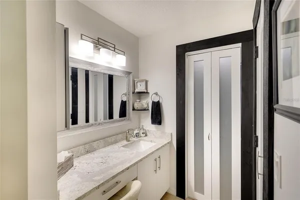 a bathroom with a granite countertop sink and a mirror