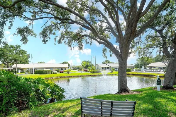 a view of a house with a yard and a large tree