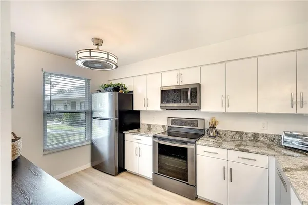 a kitchen with stainless steel appliances a stove microwave and refrigerator