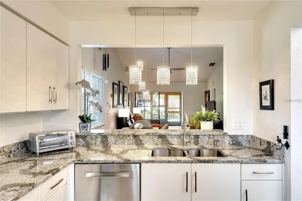 a kitchen with stainless steel appliances granite countertop a sink and a white cabinets