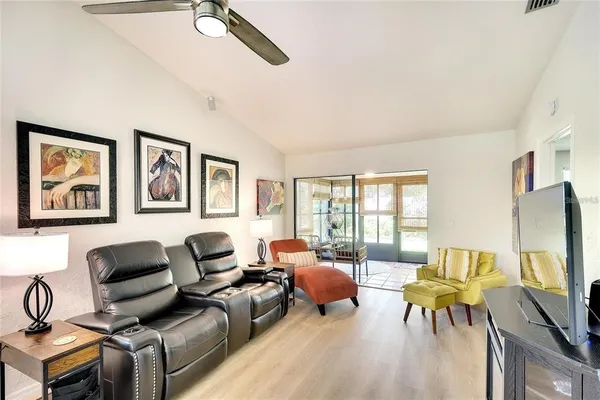 a living room with furniture a flat screen tv and a floor to ceiling window