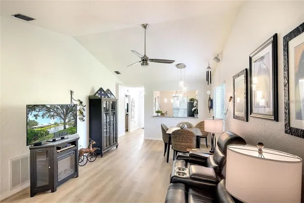 a living room with furniture a flat screen tv and a large window