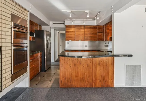 a kitchen with stainless steel appliances granite countertop a refrigerator and a sink