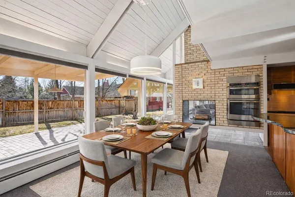 a dining room with furniture a fireplace and wooden floor