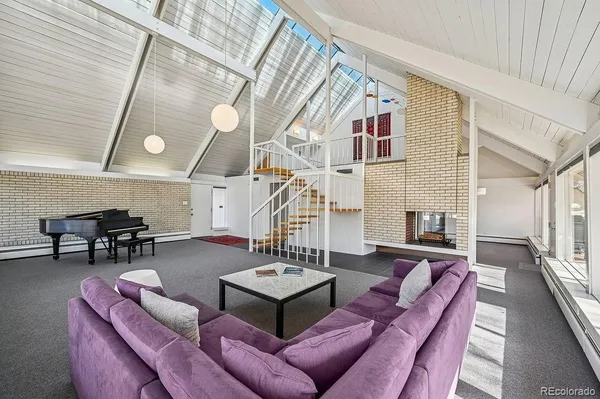 a living room with furniture a fireplace and wooden floor