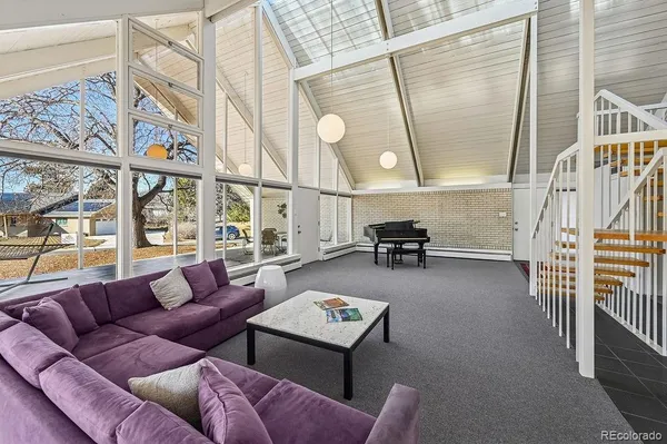 a living room with furniture a rug and a large window