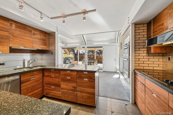 a kitchen with granite countertop a sink and wooden cabinets