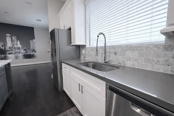 a kitchen with stainless steel appliances a sink and cabinets