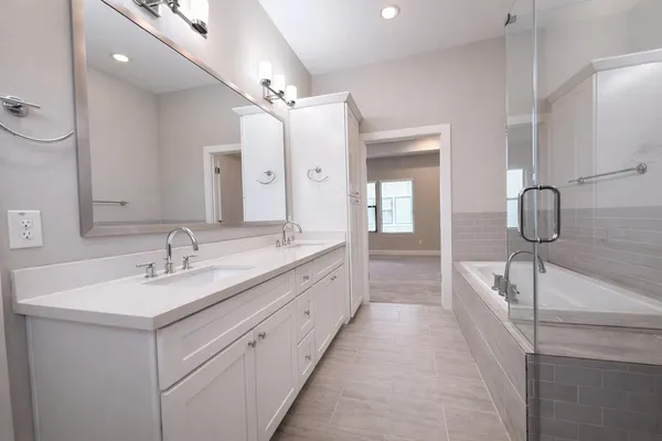 a spacious bathroom with a double vanity sink mirror and shower