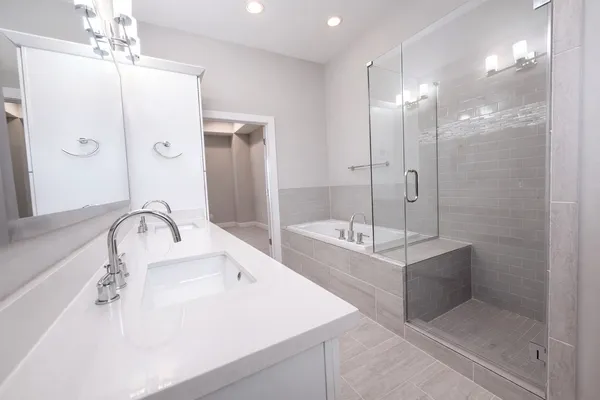 a bathroom with a tub sink shower and mirror