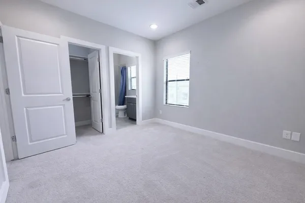 an empty room with closet and windows