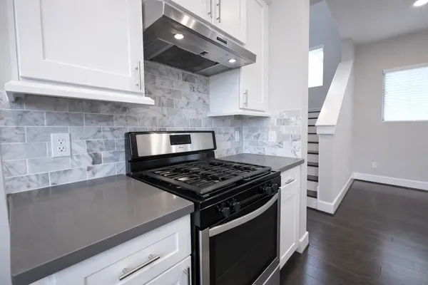 a kitchen with stainless steel appliances granite countertop a stove a sink and a microwave