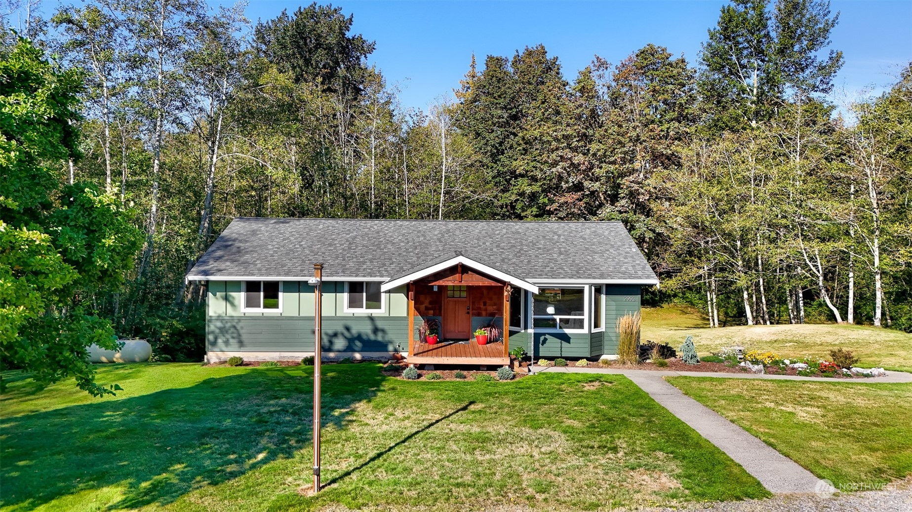 a front view of a house with a yard table and trees