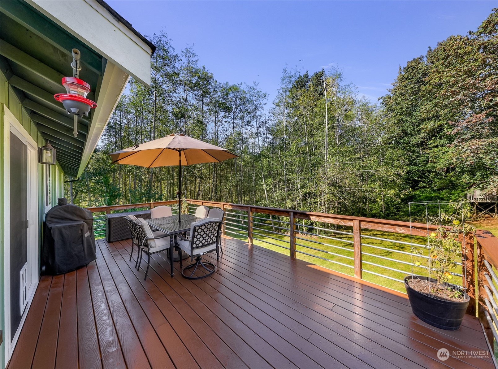 2993 Canlin Drive Ferndale, WA 98248 - Photo 17 of 35 a view of a roof deck with table and chairs under an umbrella with wooden floor