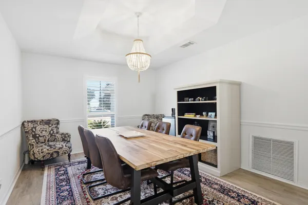 a large kitchen with lots of furniture a sink appliances dining table and wooden floor