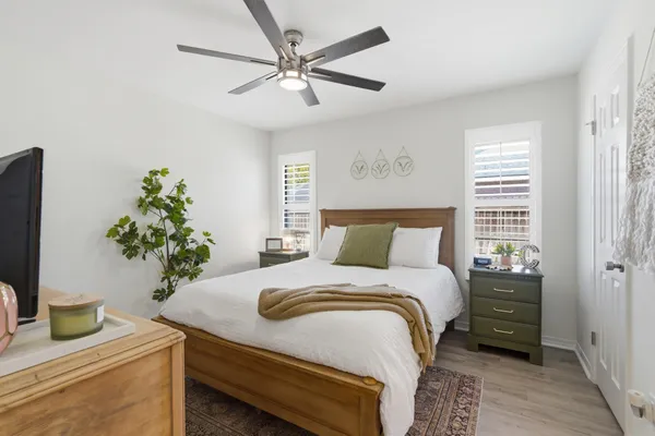a spacious bedroom with a bed furniture and a flat tv screen
