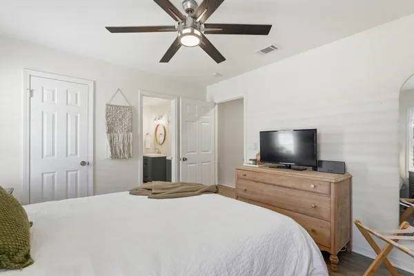 a spacious bedroom with a bed and ceiling fan