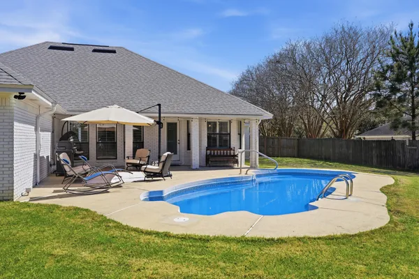a view of a house with swimming pool and sitting area