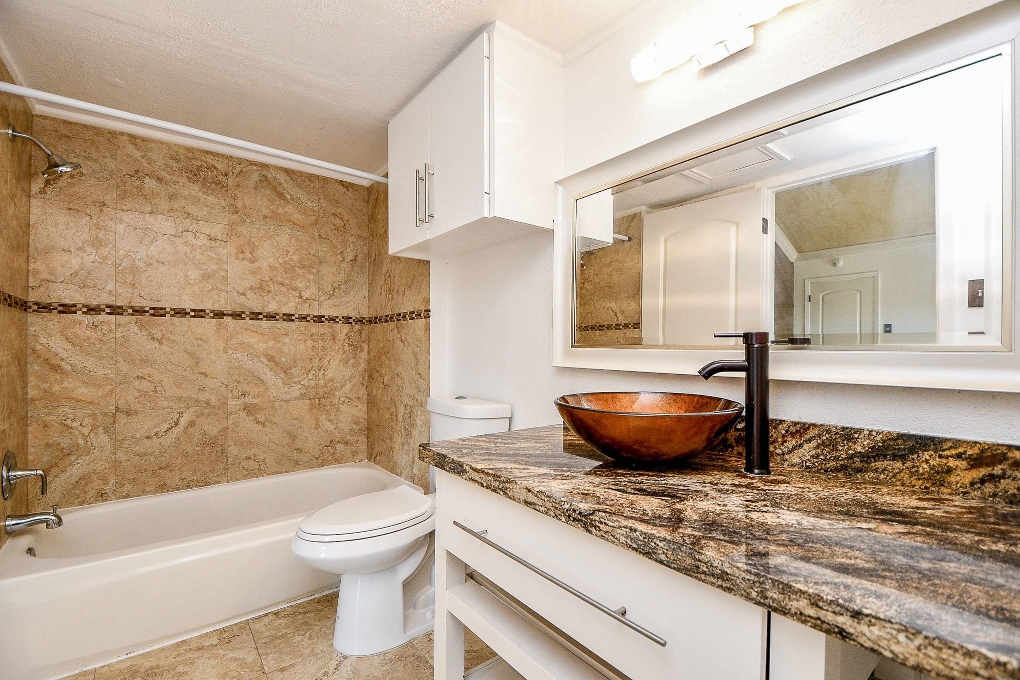 6000 Inwood Drive, Unit 1 Houston, TX 77057 - Photo 22 of 29 a bathroom with a granite countertop bathtub shower sink vanity and toilet
