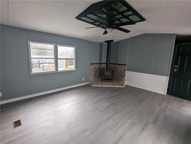 a view of empty room with a fireplace and wooden floor