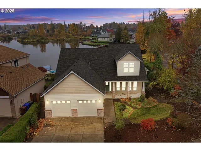 a view of a house with a yard and a large tree