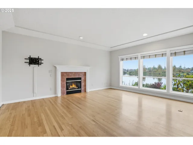 a view of an empty room with a fireplace and a window