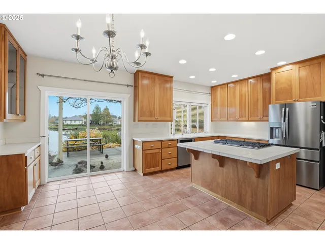 a kitchen with a stove a refrigerator a sink a dining table and chairs