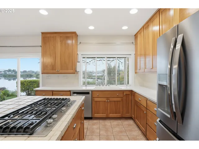 a kitchen with stainless steel appliances granite countertop a stove a refrigerator and a sink