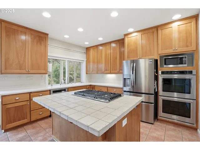 a kitchen with a refrigerator and a stove top oven