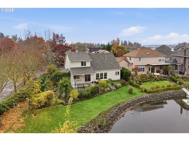 a view of a big house with a big yard and large trees